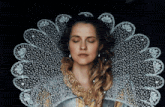 a woman with her eyes closed is wearing a lace collar around her neck