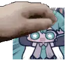 a hand is holding a cartoon character in front of a picture of a person .