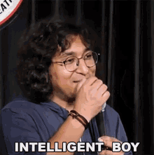 a man with glasses is speaking into a microphone and the words intelligent boy are above him