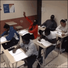 a group of people are sitting at desks in a classroom with a sign on the wall that says ' classroom rules '