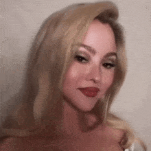 a close up of a woman with blonde hair and red lips .