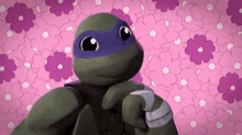a turtle is standing in front of a pink flower background .