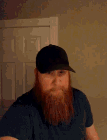 a man with a beard is wearing a black hat