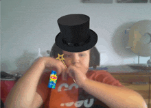 a person wearing a top hat and holding a lipton spray