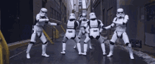 a group of stormtroopers are dancing in an alleyway
