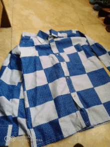 a blue and white checkered shirt is photographed by a phone