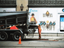 a truck is parked in front of a billboard that says any task