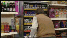 a man in a brown vest is standing in front of a store shelf with a bottle of coca cola on it