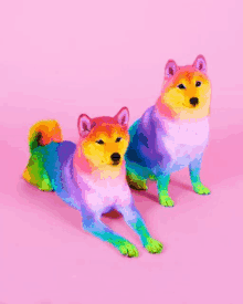 two rainbow colored dogs are laying on a pink background