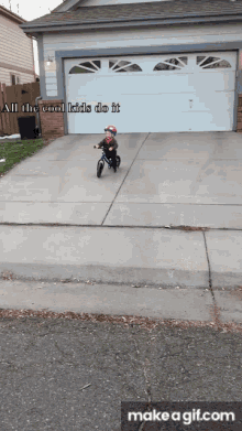 a little boy is riding a bike in front of a garage with the words all the cool kids do it above him