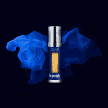 a bottle of la prairie skin caviar lotion is surrounded by blue fabric