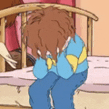 a cartoon character is sitting in a crib with his hands on his face .