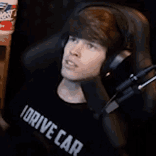 a young man wearing headphones and a shirt that says i drive car