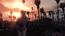 a woman in a pink shirt is standing in front of a sunset