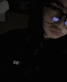 a girl wearing glasses and a black shirt that says 08