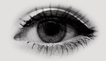 a close up of a woman 's eye with long eyelashes and a black pupil .