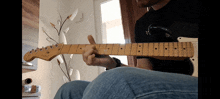 a man playing an electric guitar with a black shirt on