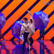 a man and a woman are dancing on a stage with umbrellas behind them and the word talent on the bottom