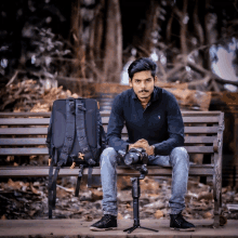 a man is sitting on a bench with a camera and a backpack