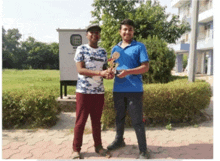 two young men standing next to each other holding trophies