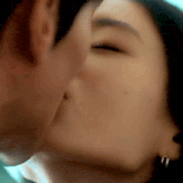 a close up of a man and a woman kissing