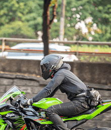 a person is riding a green and black ninja motorcycle