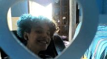 a young boy with blue hair is smiling in a heart shaped mirror