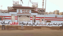 a man is holding a banner in front of a building that says 3 on it