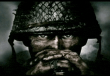 a black and white photo of a soldier with his hands covering his mouth