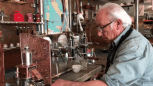 a man is working on a coffee machine in front of a map that says ' italy ' on it