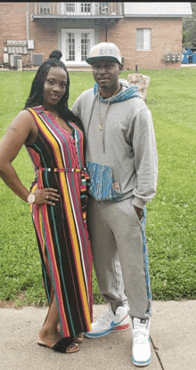 a woman in a striped dress stands next to a man wearing a hat that says ucsd