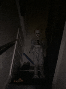 a person dressed as a clown is standing on a set of stairs in the dark