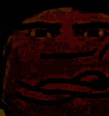 a close up of a man 's face in a dark room with a red background .