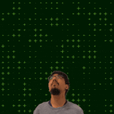 a man with glasses stands in front of a green background with the number 6 and 1 on it