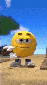a yellow smiley face with arms and legs is standing on a beach