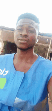 a man wearing a blue vest with the word aid on it takes a selfie