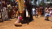 a group of people are standing around a statue of an elephant with the words arn media on the bottom right