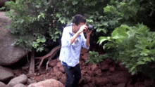 a man in a blue shirt is taking a picture with his camera