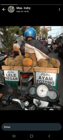 a man on a motorcycle is selling durian and chicken