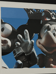 a picture of mickey mouse and minnie mouse waving