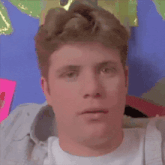 a man wearing a crown is making a funny face while making a funny face .