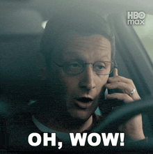 a man in a car talking on a cell phone with the words oh wow on the bottom