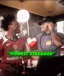 a man in a red shirt is talking to a man in a purple shirt in a restaurant .