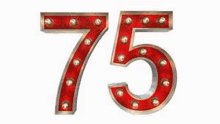 the number 75 is made of red light bulbs and has a silver frame .