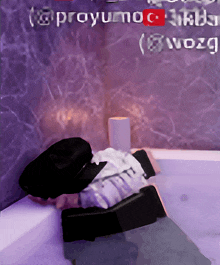 a person laying in a bathtub with a purple wall behind them that says @proyumoc