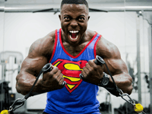 a man wearing a superman shirt is lifting weights