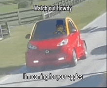 a red car is driving down a road with the words watch out howdy i 'm coming for your apples