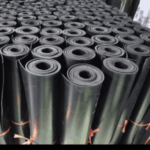 a bunch of black rubber rolls are stacked together