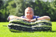 a man laying on top of a very large vegetable