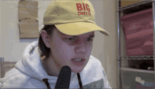 a young man wearing a yellow hat that says big cheese